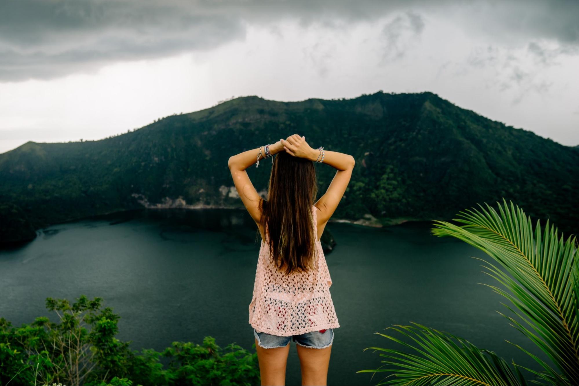 Woman sitting in front of green lake, Taal Volcano, Tagaytay, Philippines