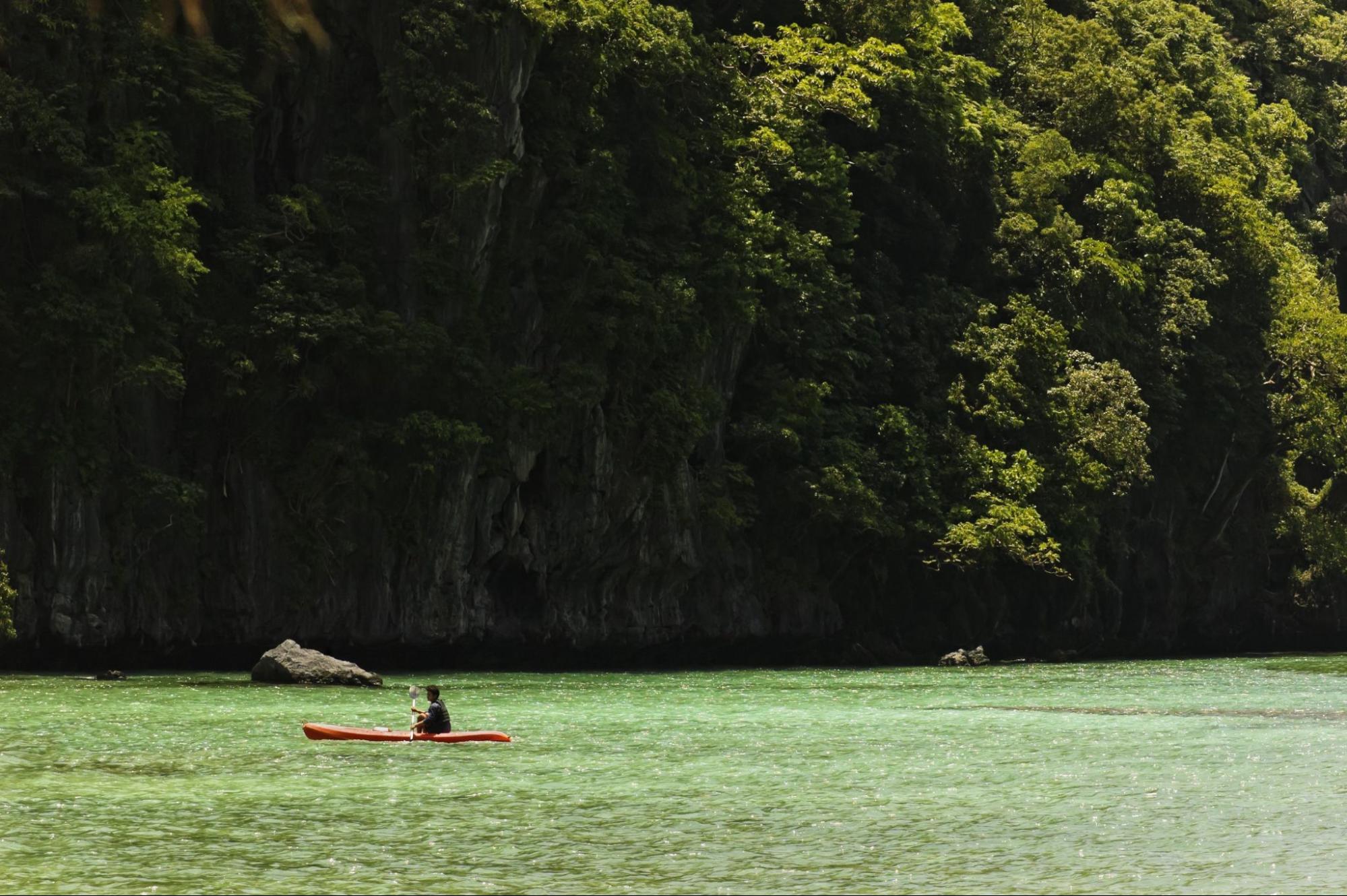 Young man kayaking in the big lagoon of El Nido, Palawan, Philippines